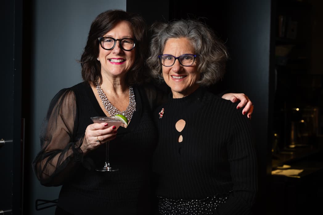 Two women smiling together at elegant holiday cocktail party — Cincinnati event photographer K Dalton