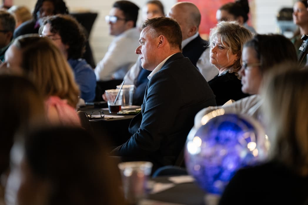 Audience of professionals listening attentively at corporate conference dinner event — Cincinnati event photographer K Dalton