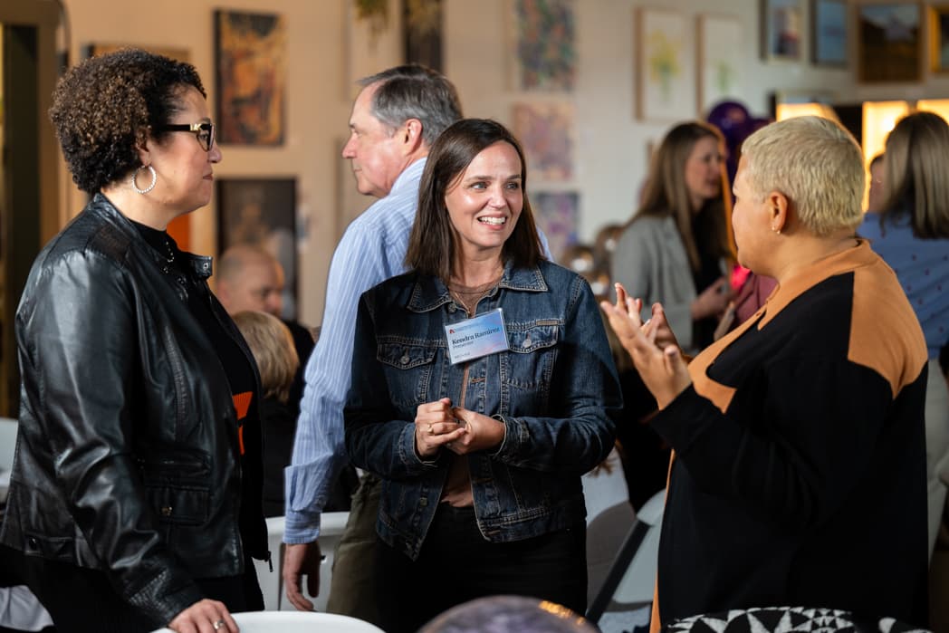Three women networking and laughing at corporate event in art gallery venue — Cincinnati event photographer K Dalton