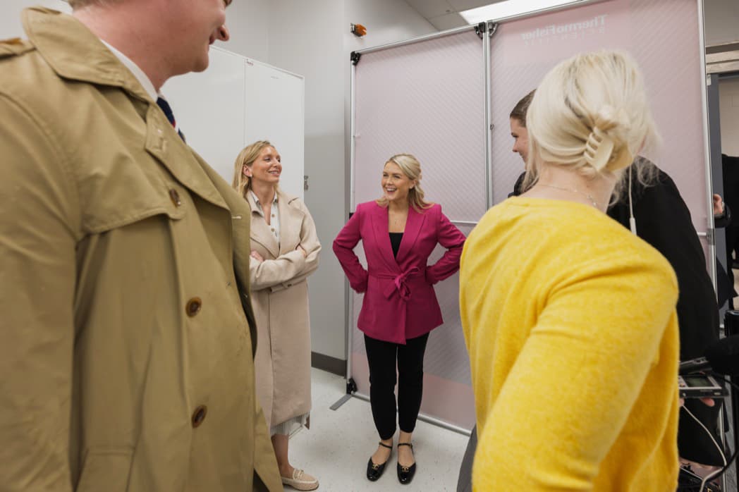 White House Press Secretary Karoline Leavitt in pink jacket laughing with colleagues at corporate facility event — Cincinnati event photographer K Dalton